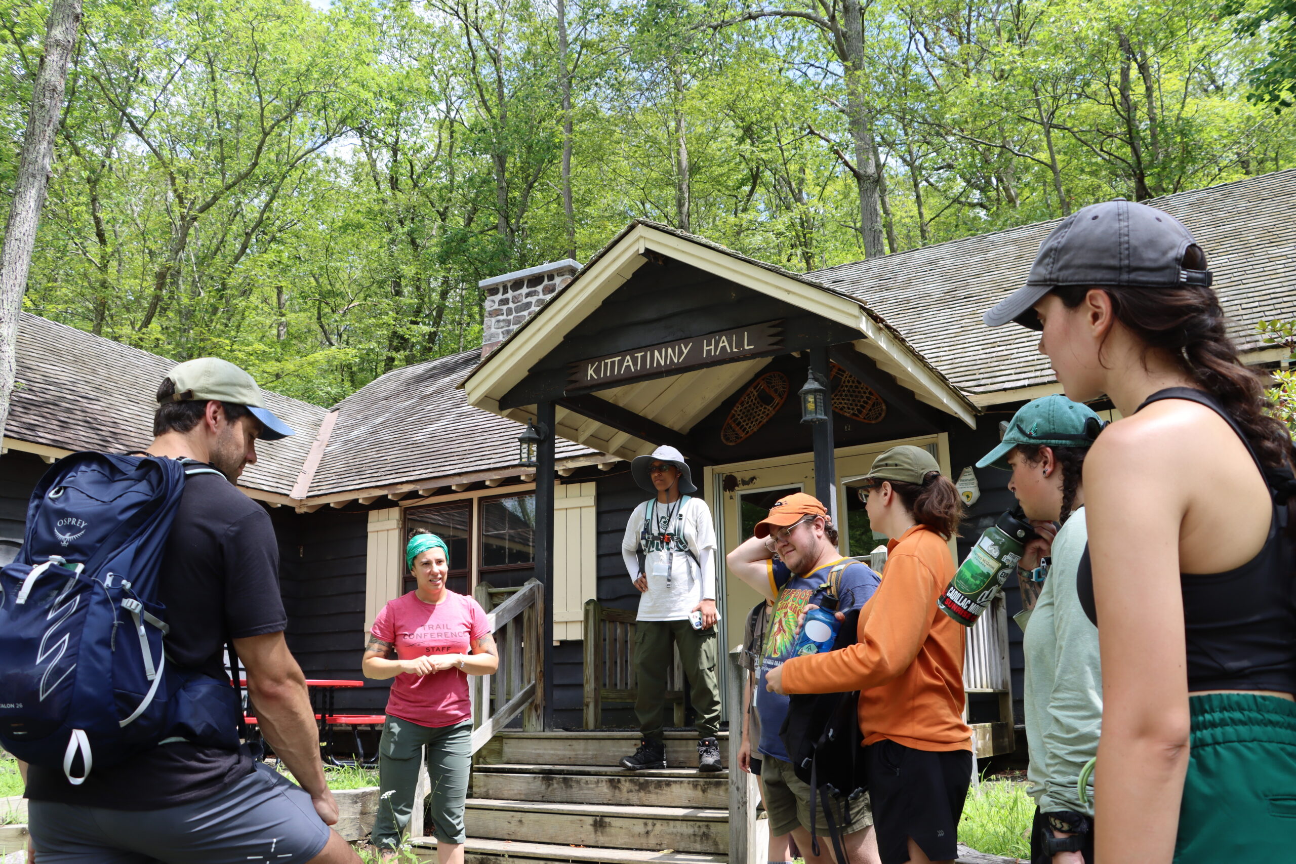 Several young people wearing outdoor clothing standing in front of a building named "Kittatinny Hall"